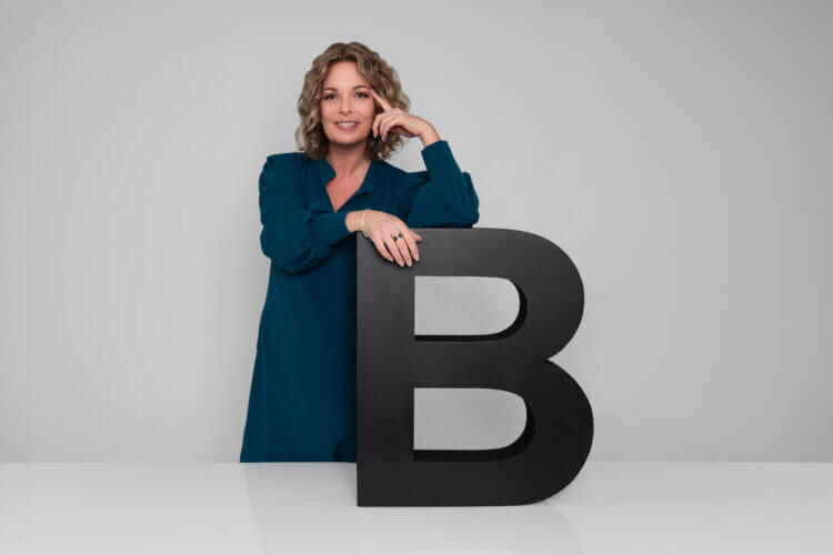 Claudia Bouwens mit dem Buchstaben B als Symbol für Bewegen und Teamentwicklung